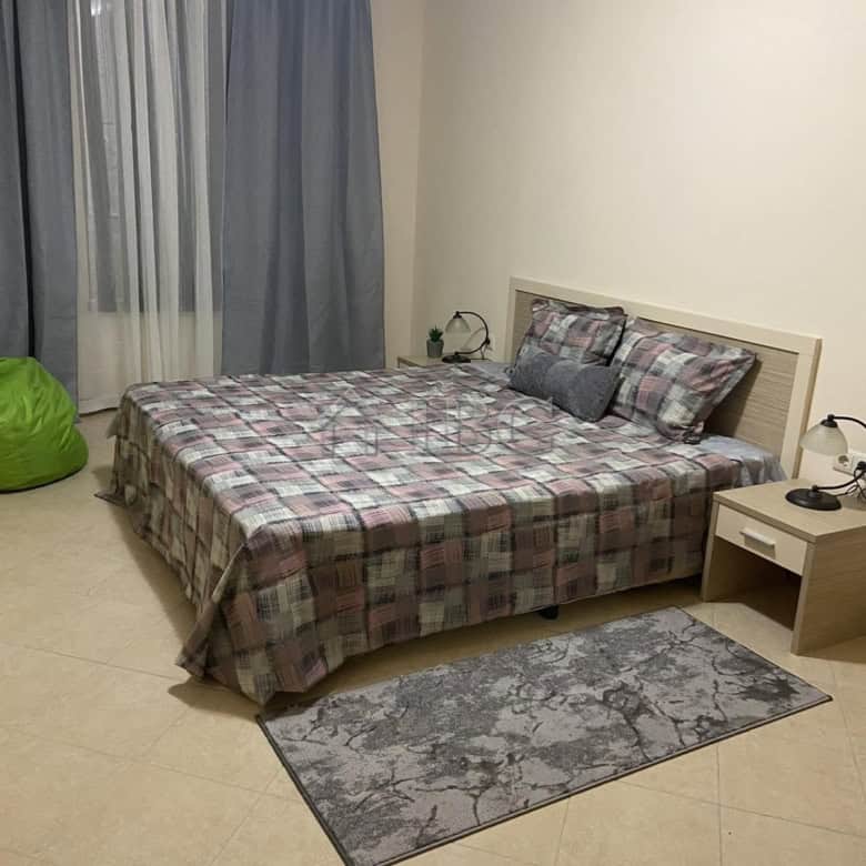 Furnished one-bedroom apartment with bed, nightstands, and curtains in Sunny Beach.