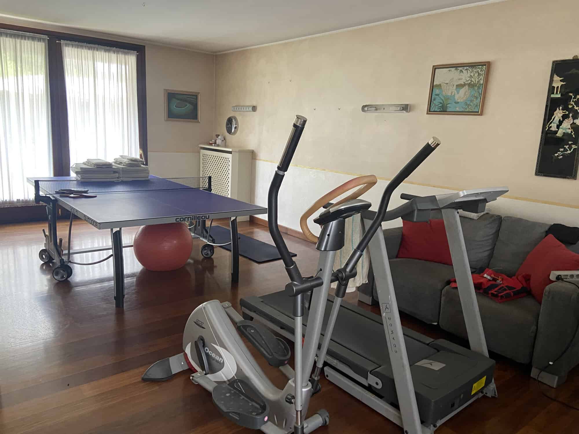 Home gym setup with treadmill and exercise bike in a cozy living room.