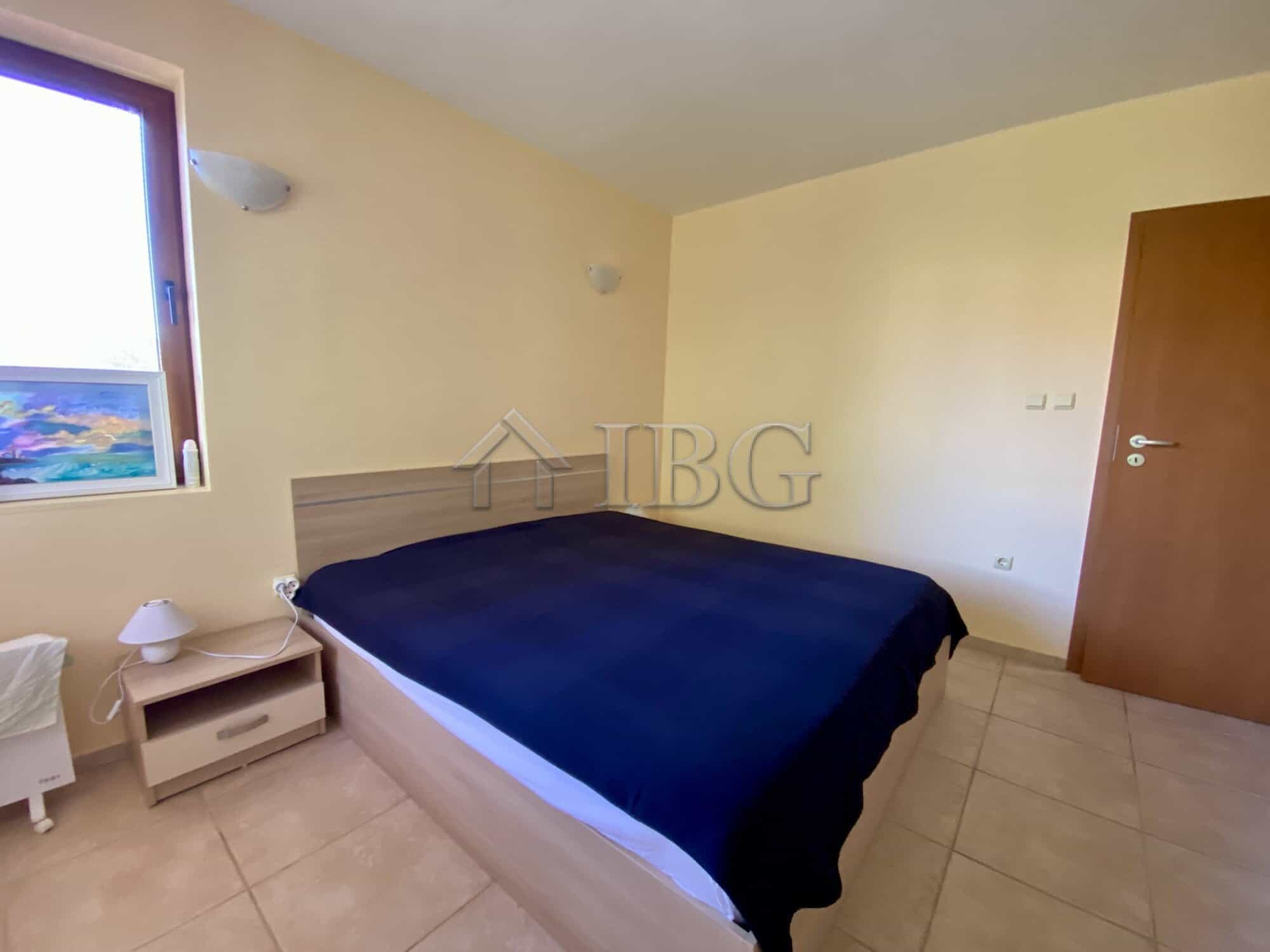 Cozy bedroom with a large window overlooking the pool area in Chateau Del Mar, Sunny Beach.