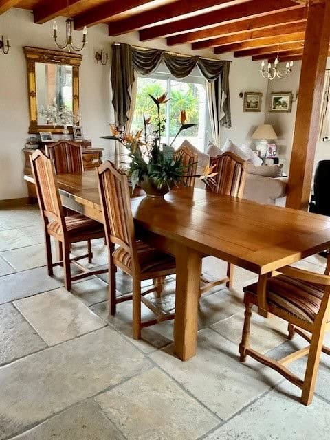 Charming interior of a dining area featuring a wooden table, chairs, and decorative elements.