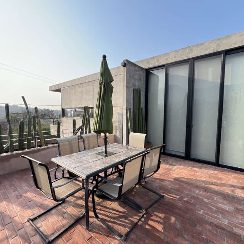 Modern rooftop terrace with outdoor dining area and city views.