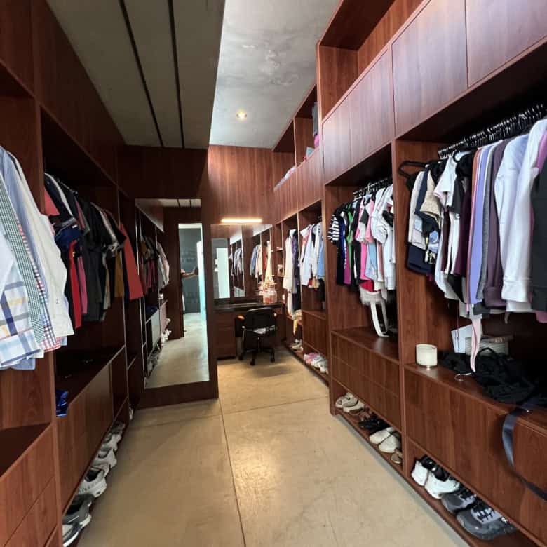 Luxury walk-in closet with wooden shelving and clothing racks for stylish storage solutions.