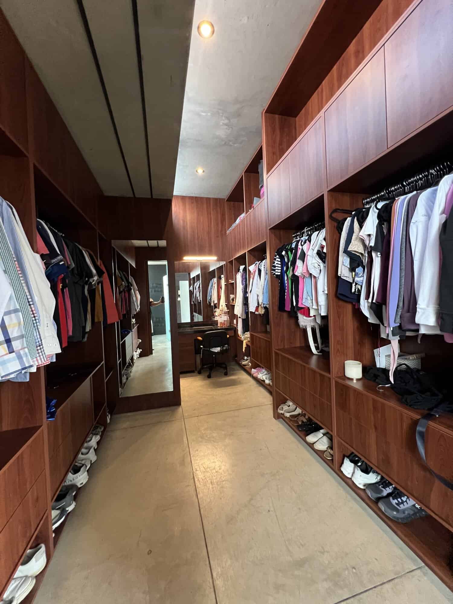 Luxury walk-in closet with wooden shelving and clothing racks for stylish storage solutions.