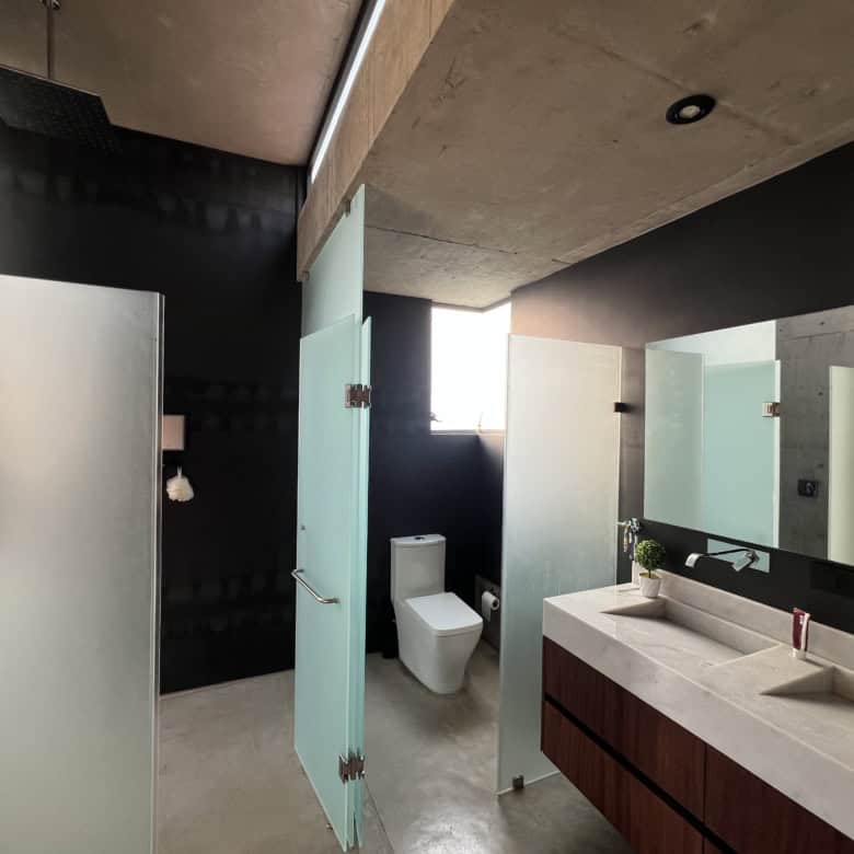Modern bathroom with glass shower enclosures and sleek fixtures.