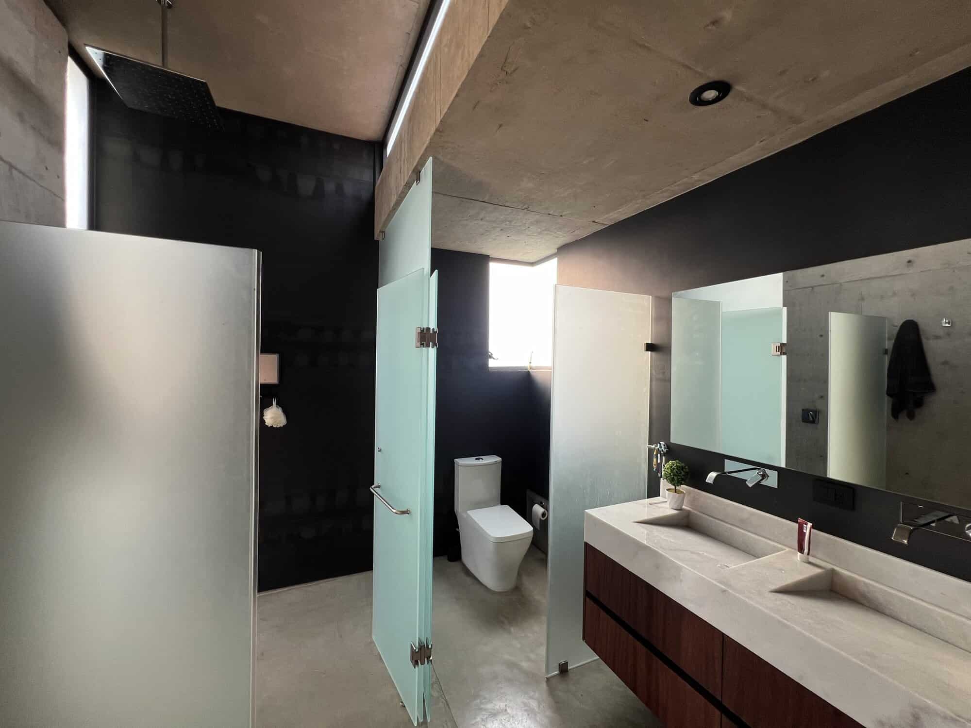 Modern bathroom with glass shower enclosures and sleek fixtures.