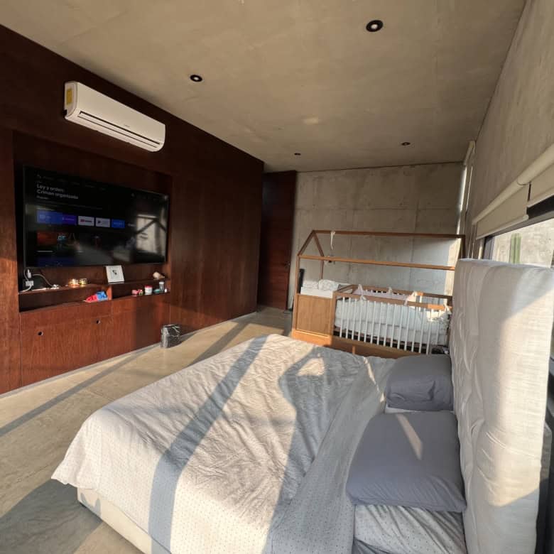 Modern bedroom with large window and minimalist decor for a bright, airy living space.