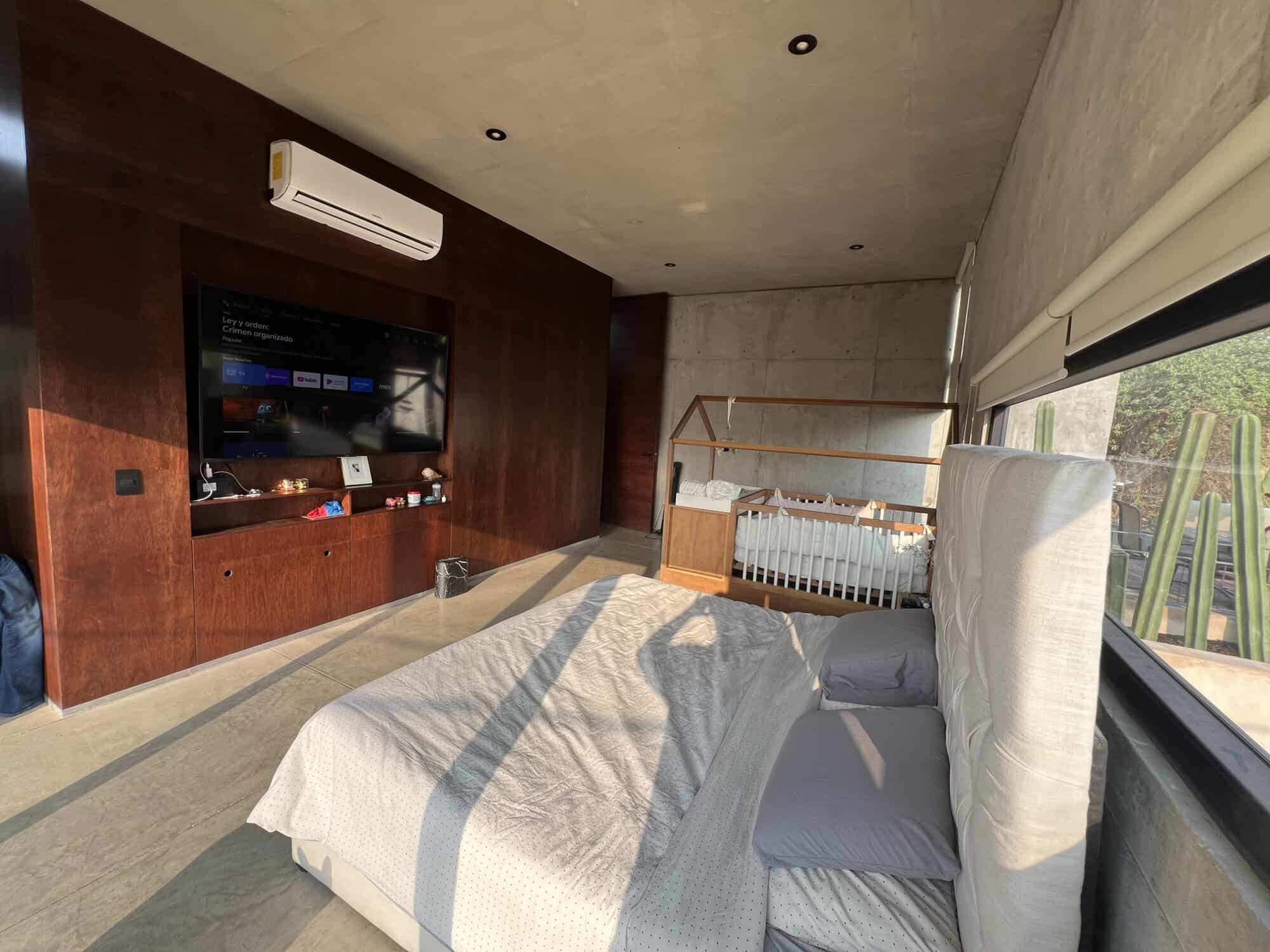 Modern bedroom with large window and minimalist decor for a bright, airy living space.