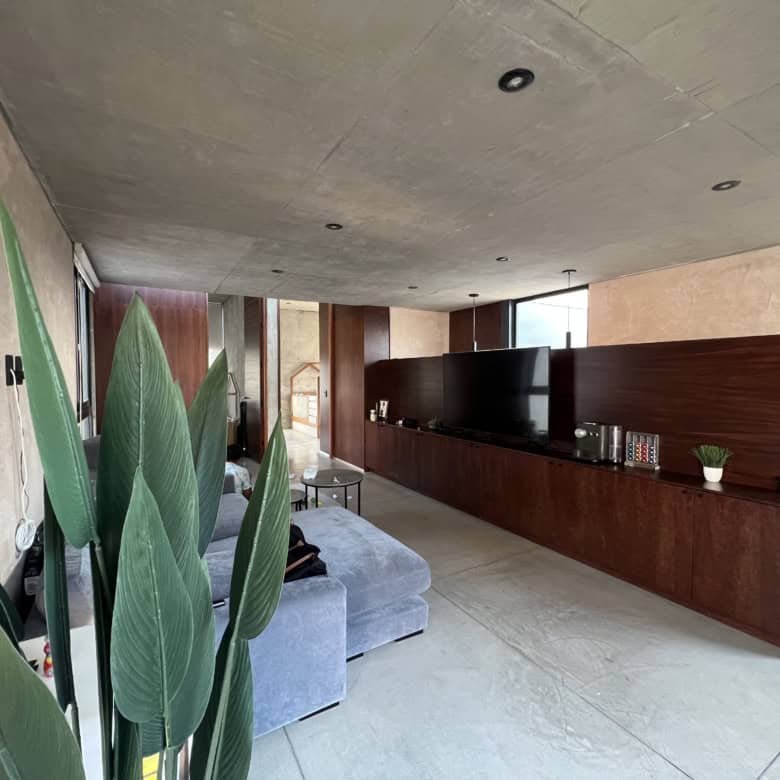 Modern living room with minimalist decor and large windows.