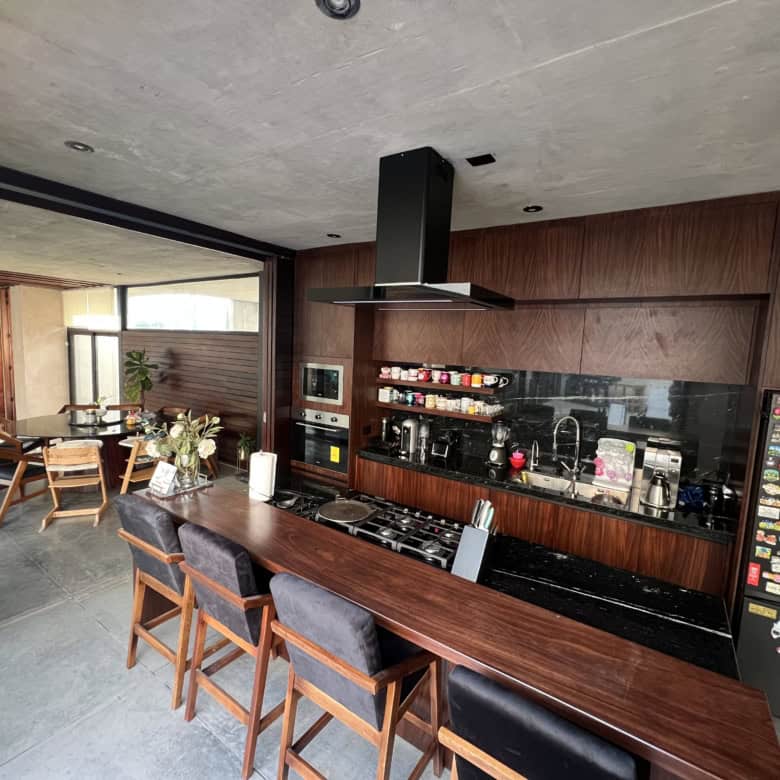 Modern kitchen with wooden cabinets and black countertops.