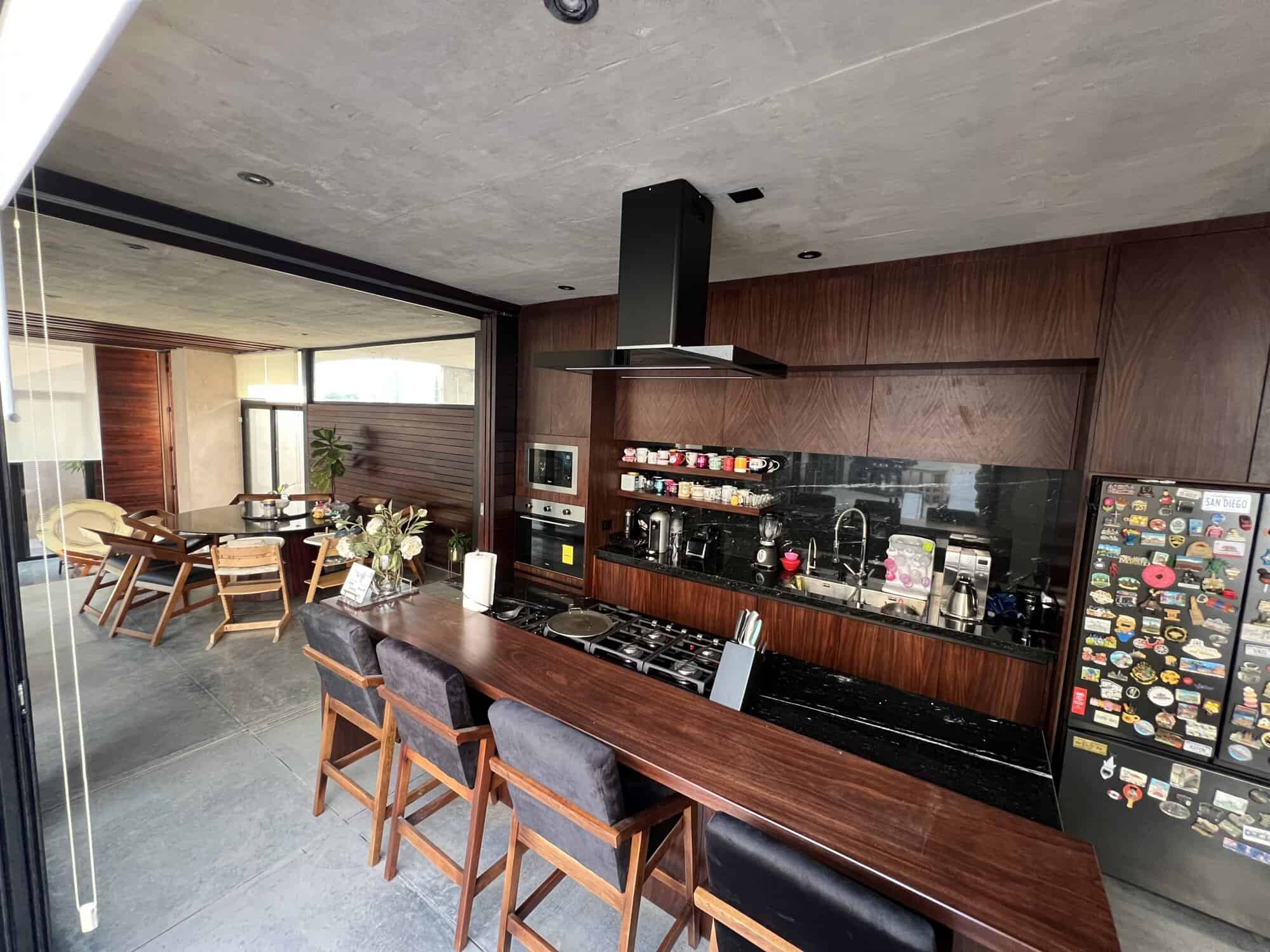 Modern kitchen with wooden cabinets and black countertops.