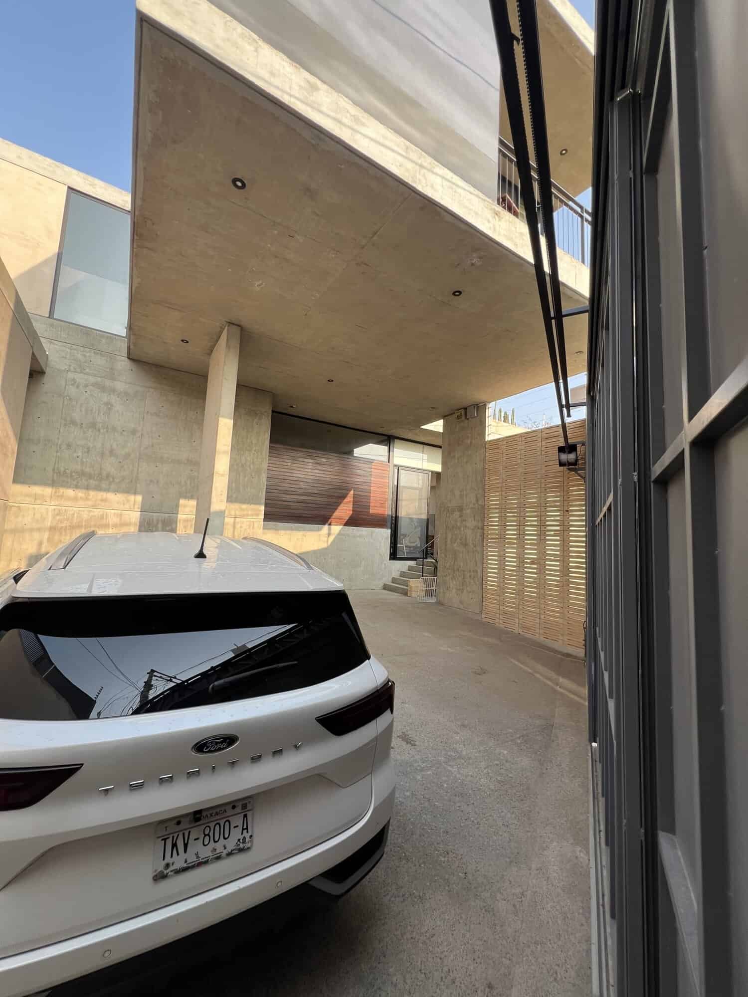 Contemporary concrete home with sleek design and parking area.