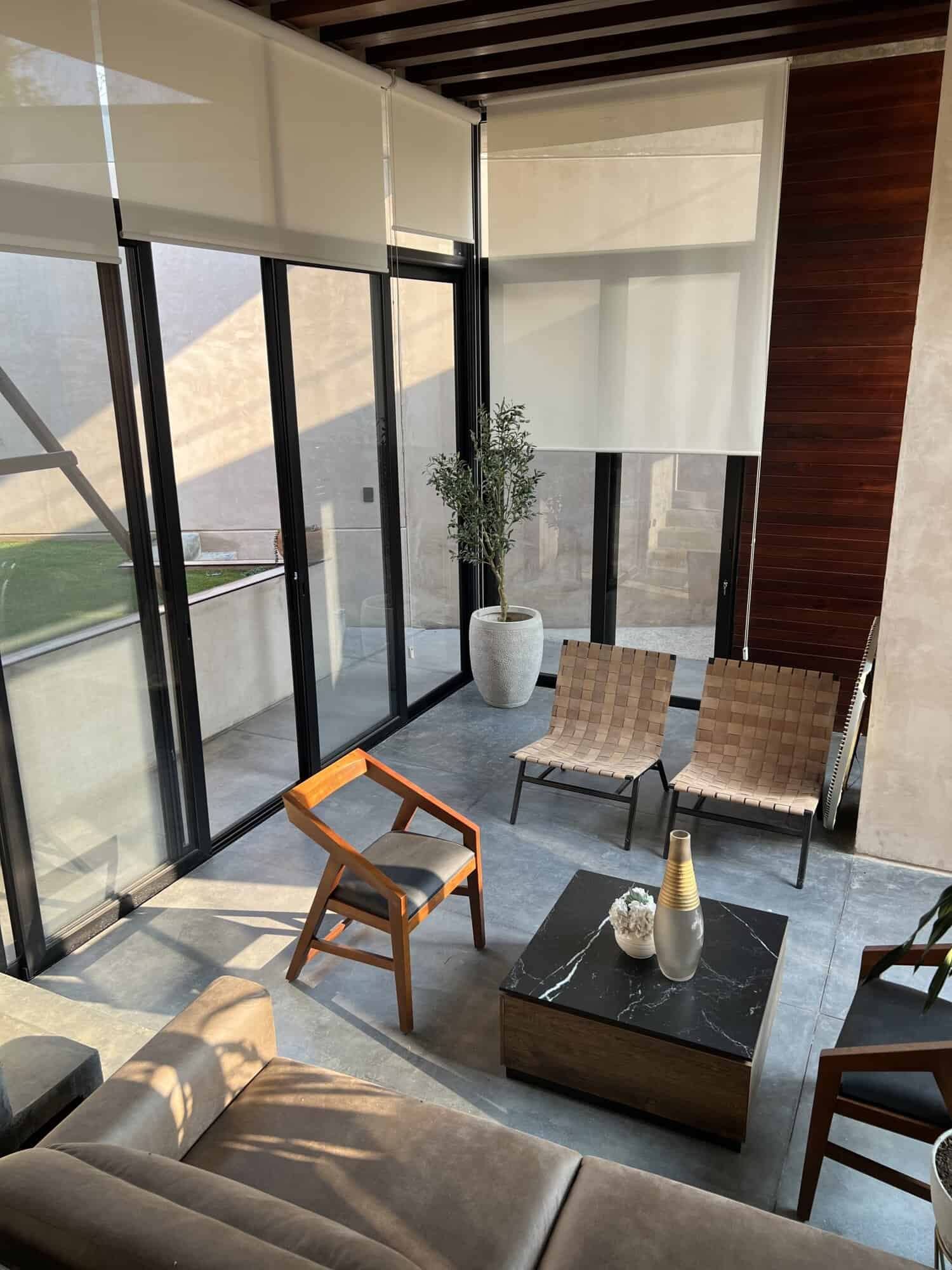 Indoor lounge area with large glass windows and stylish furniture.