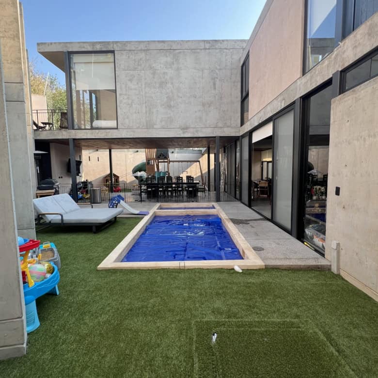 Modern luxury house with private pool and outdoor seating area.