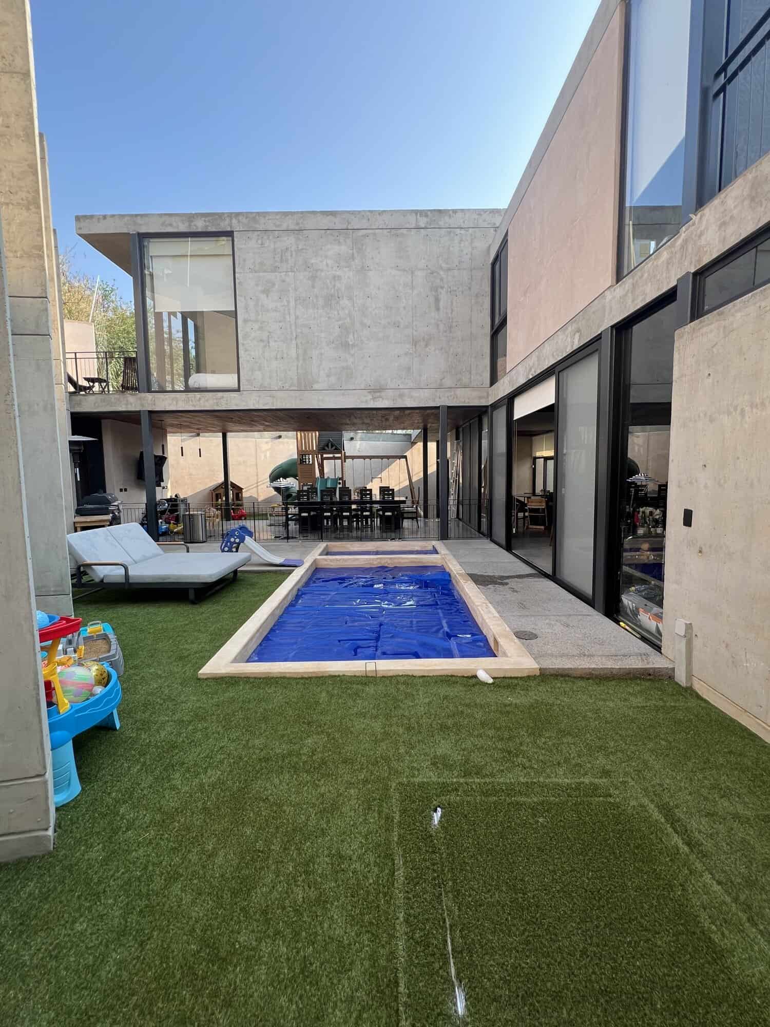 Modern luxury house with private pool and outdoor seating area.