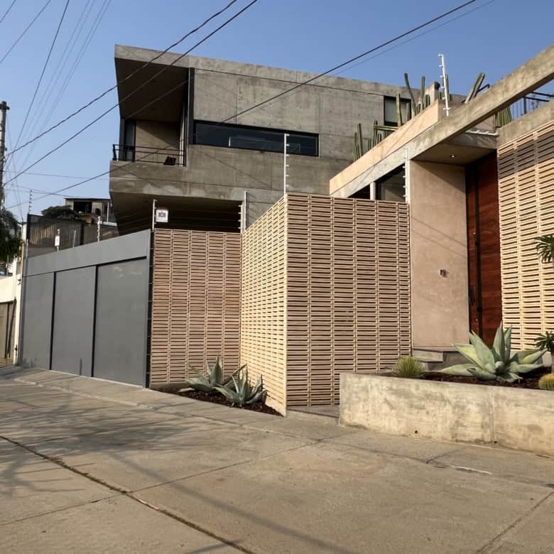 Stylish modern house featuring concrete and wooden design elements in an urban setting.