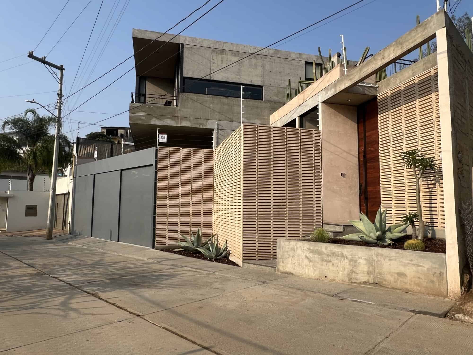 Stylish modern house featuring concrete and wooden design elements in an urban setting.