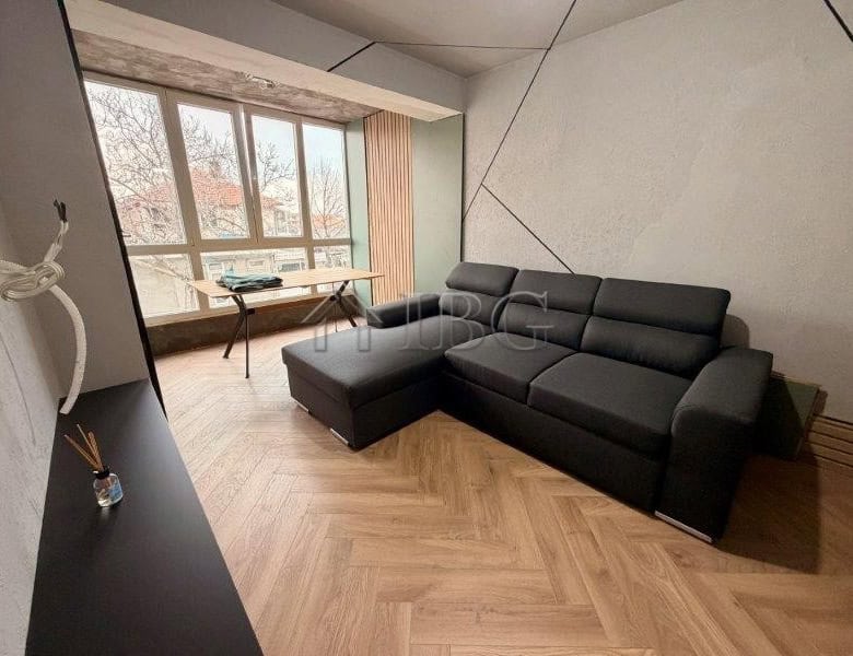 Spacious living room with large windows and contemporary furniture in Ravda residential building.