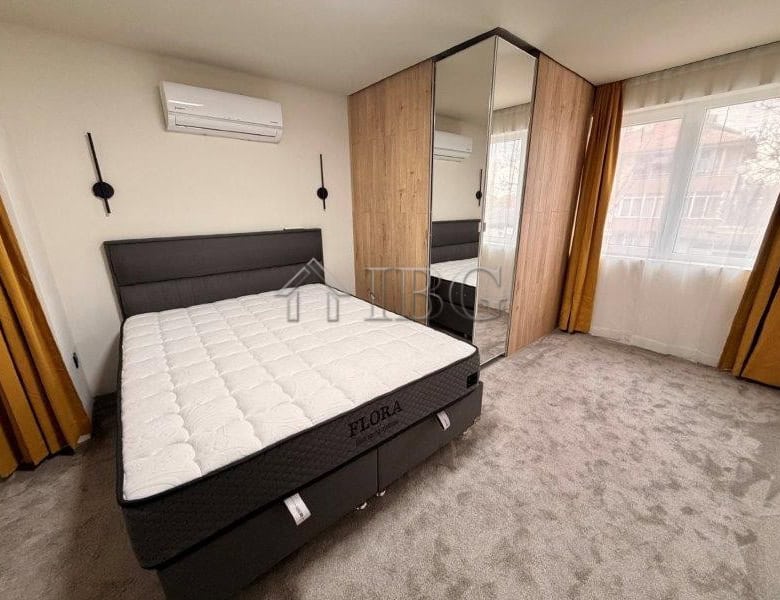 Bright bedroom with large window and wardrobe in Ravda apartment.