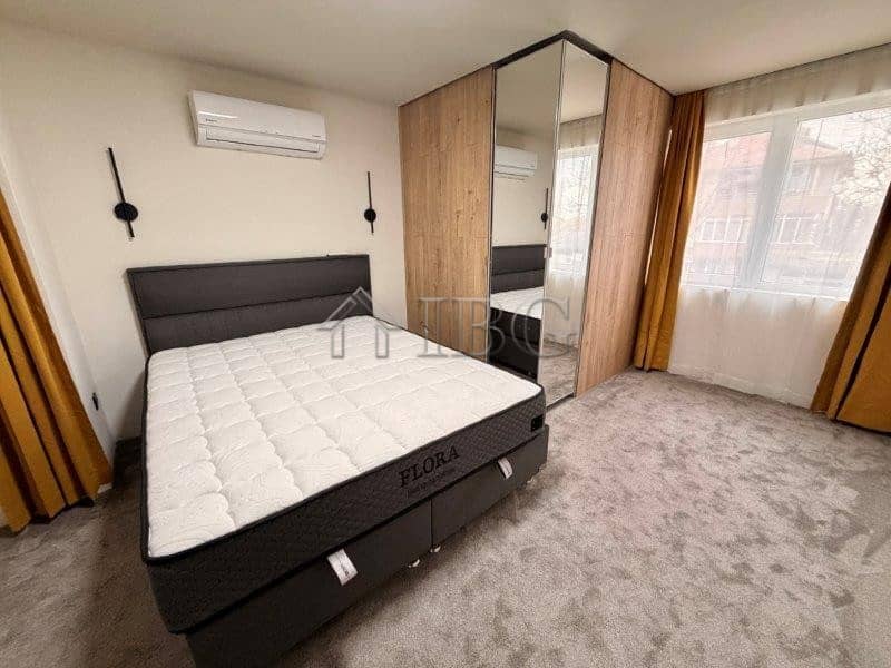 Bright bedroom with large window and wardrobe in Ravda apartment.