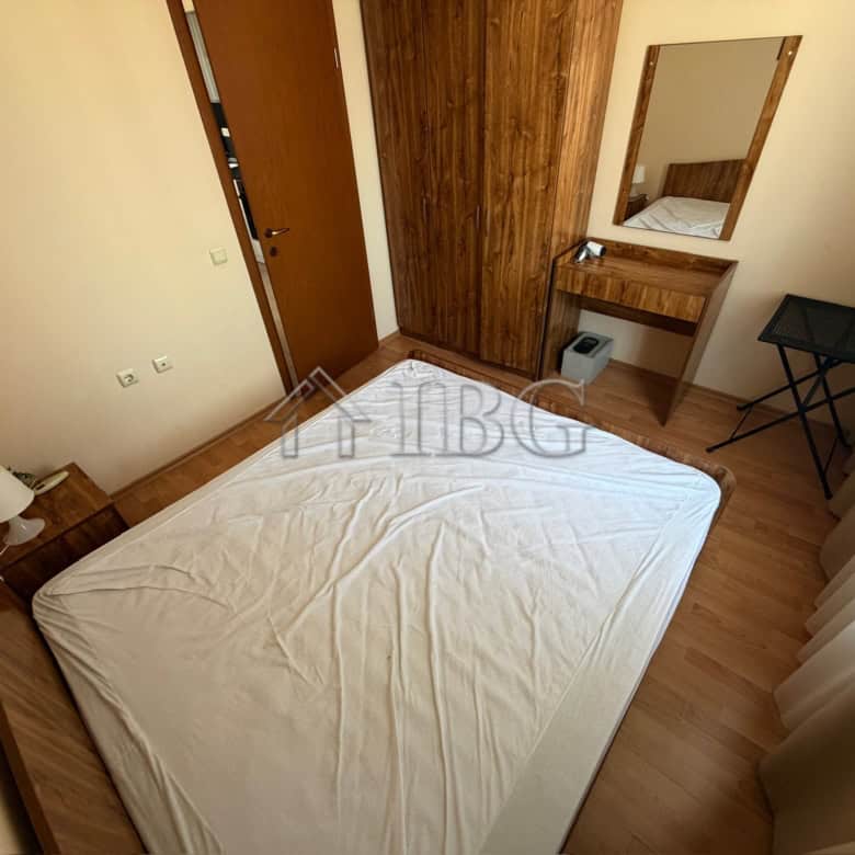 Bright bedroom with wooden furniture and a large mirror.