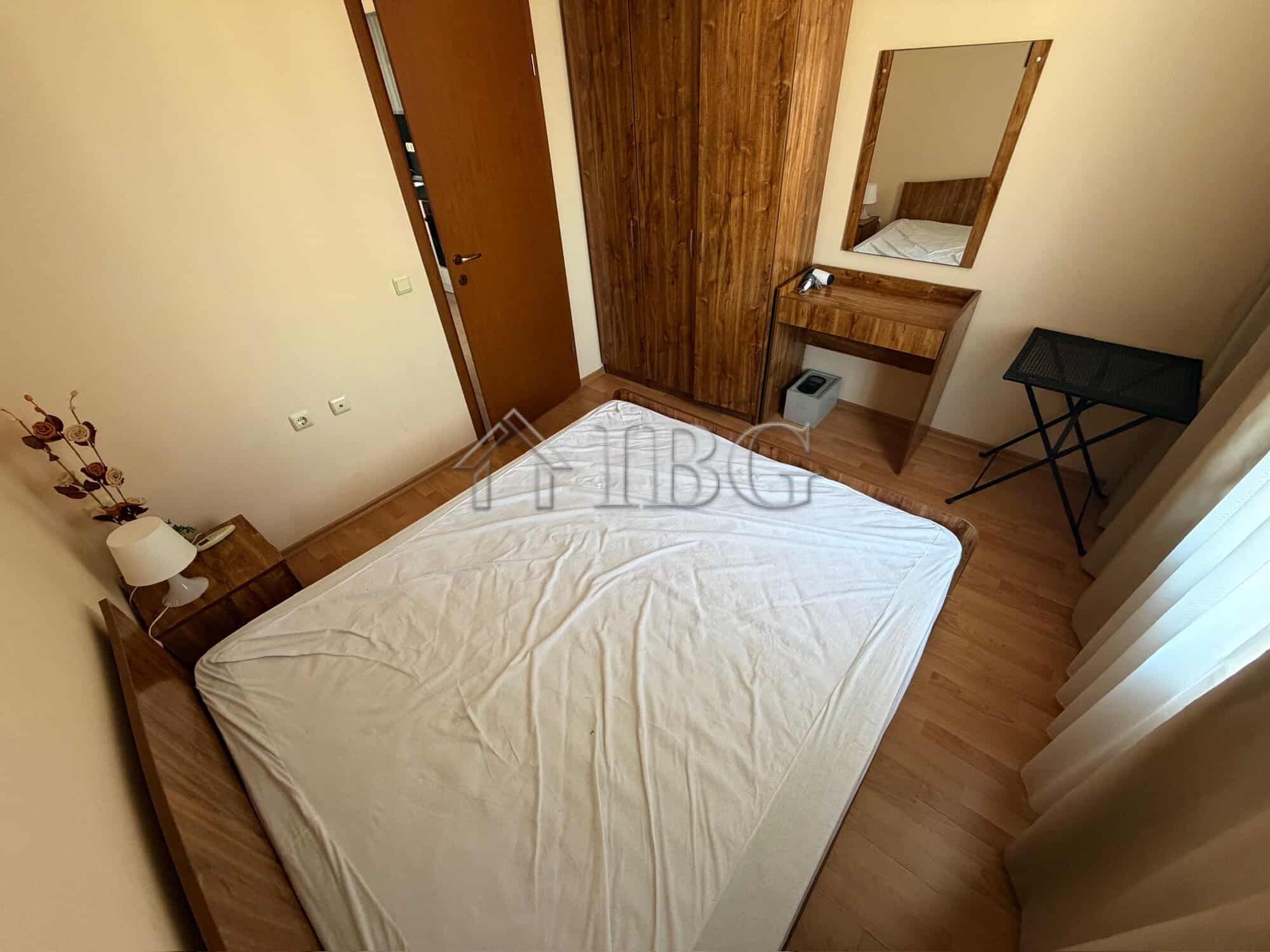Bright bedroom with wooden furniture and a large mirror.