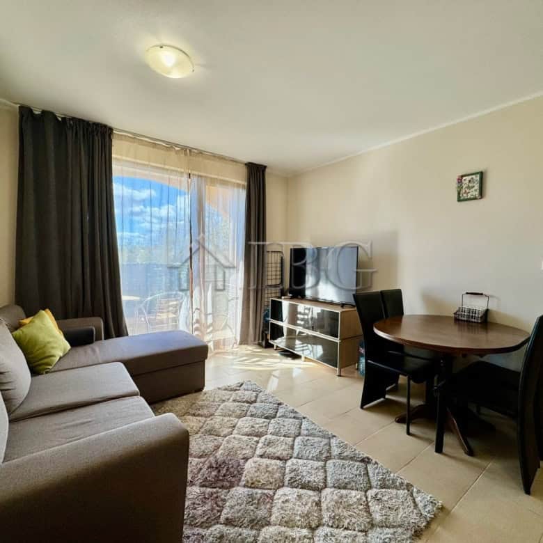 Cozy 1-bedroom apartment with pool view, living area, and balcony in Sunny Beach.