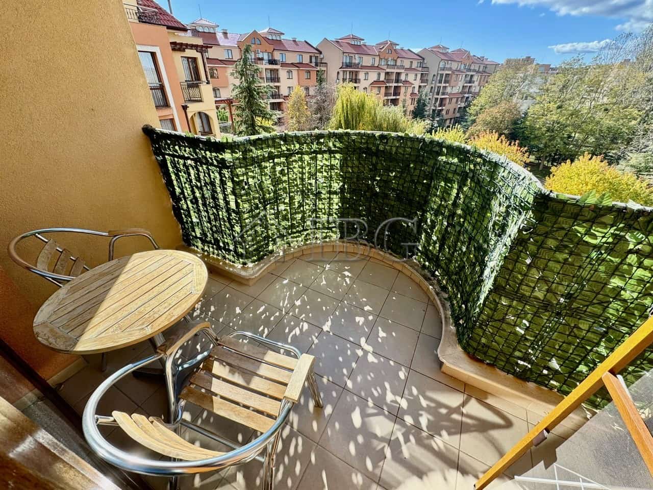 Cozy Balcony with Green View in Sunny Beach Balcony with lush greenery and outdoor seating overlooking Sunny Beach apartments. Perfect for relax.