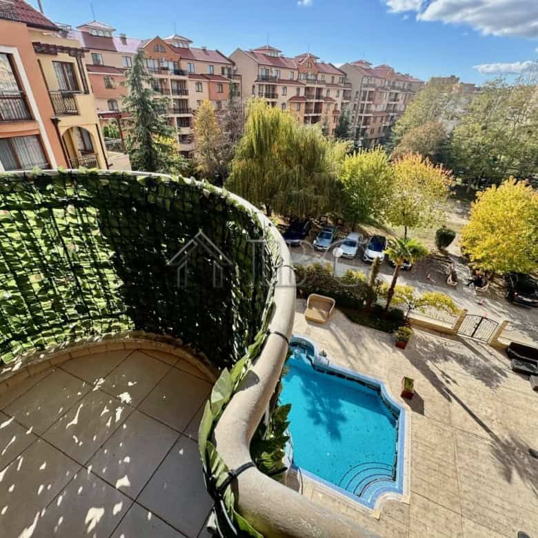 Balcony view of pool and lush greenery from a 1-bedroom apartment in Sunny Beach.