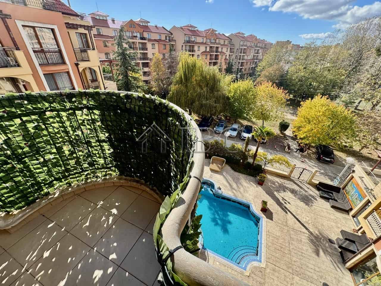 Cozy apartment with pool view in Sunny Beach Balcony view of pool and lush greenery from a 1-bedroom apartment in Sunny Beach.