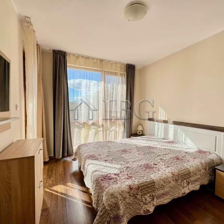 Bright bedroom with large window overlooking pool in Harmony Suites 1, Sunny Beach.