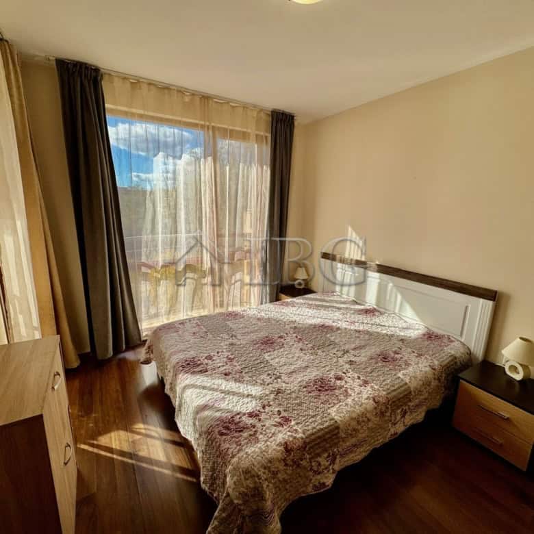 Spacious bedroom with large window overlooking the pool at Harmony Suites 1, Sunny Beach.