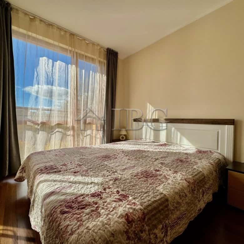 Bright bedroom with large window overlooking the pool in Harmony Suites 1, Sunny Beach.