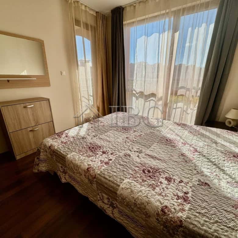 Bedroom with large windows overlooking the pool in Harmony Suites 1, Sunny Beach.
