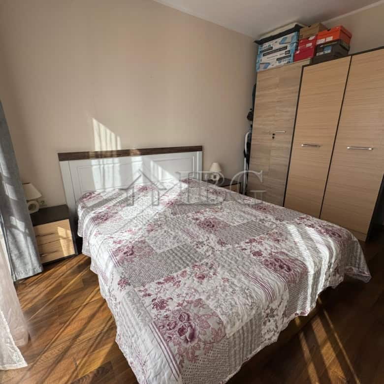 Bright bedroom with a large bed, wardrobe, and sunlight streaming through the window.