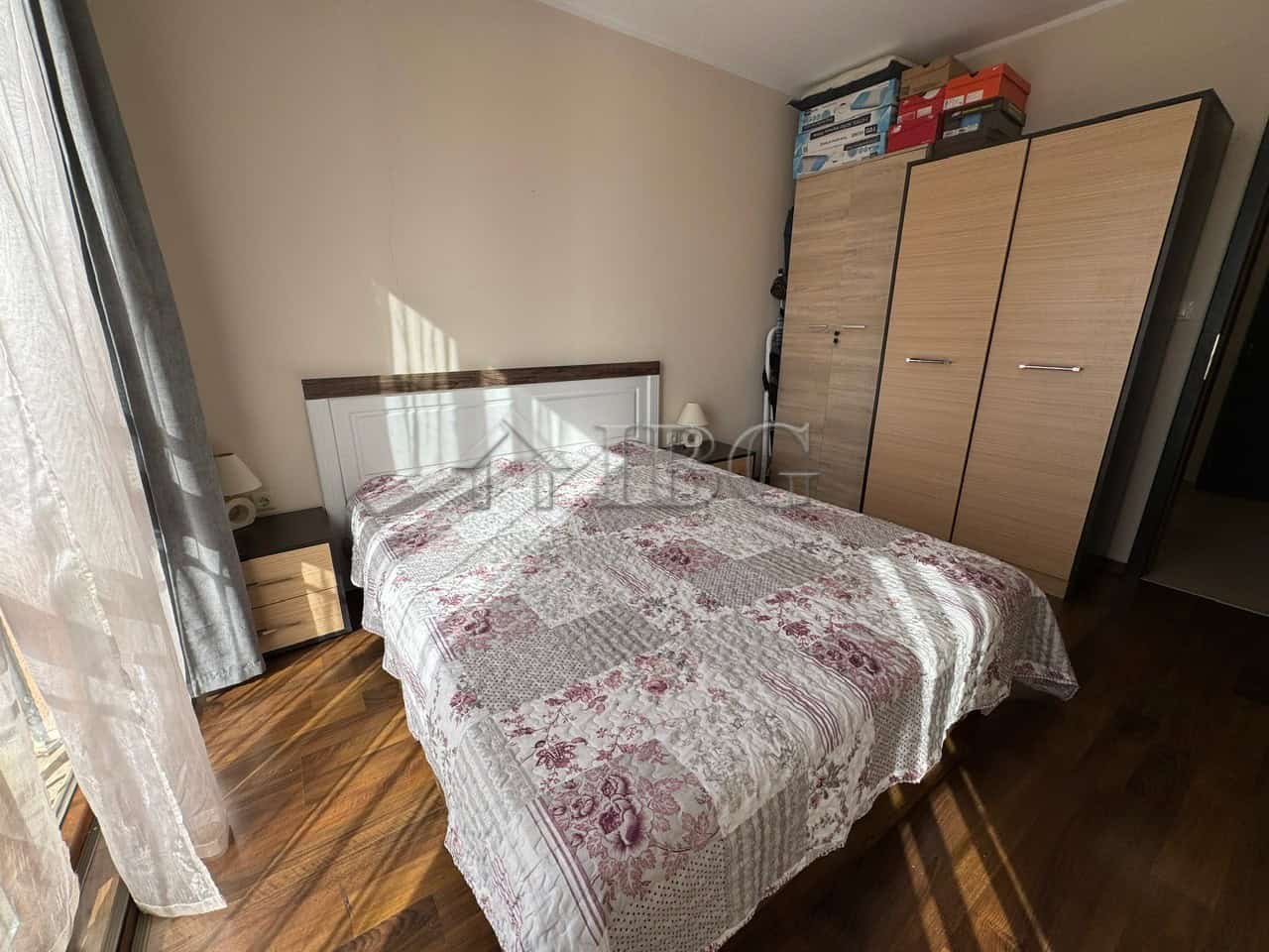 Cozy Bedroom with Wardrobe and Natural Light Bright bedroom with a large bed, wardrobe, and sunlight streaming through the window.
