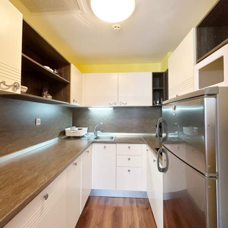 Bright, fully equipped kitchen with white cabinets and dark countertops in Sunny Beach apartment.