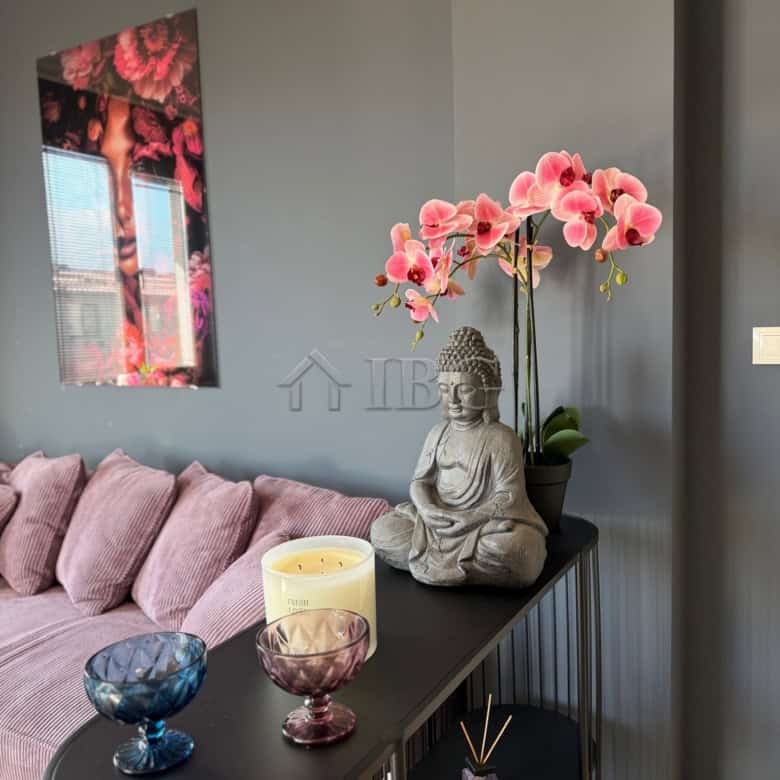 Elegant apartment interior with decorative Buddha statue and pink orchids in Nessebar.