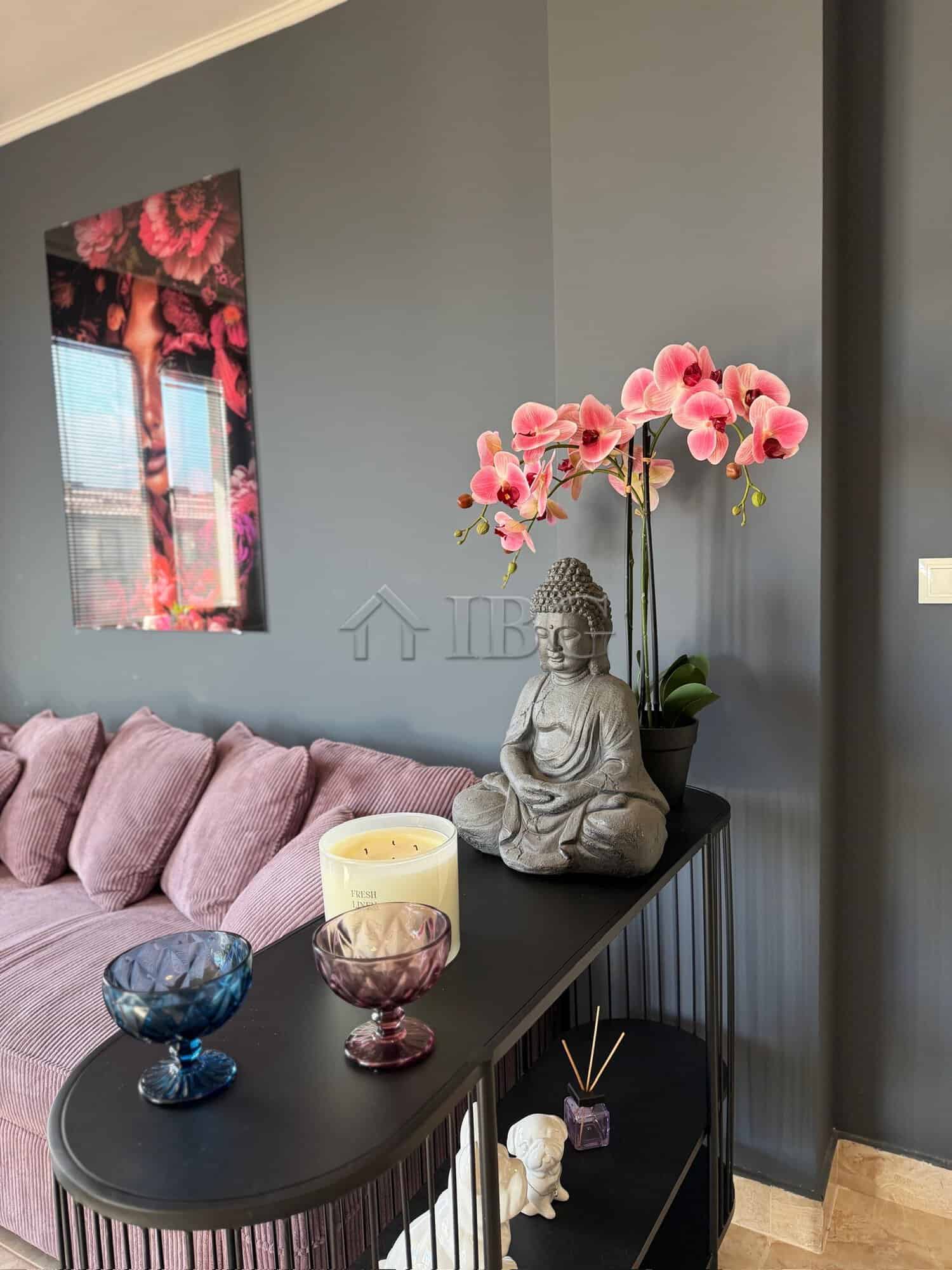 Elegant apartment interior with decorative Buddha statue and pink orchids in Nessebar.