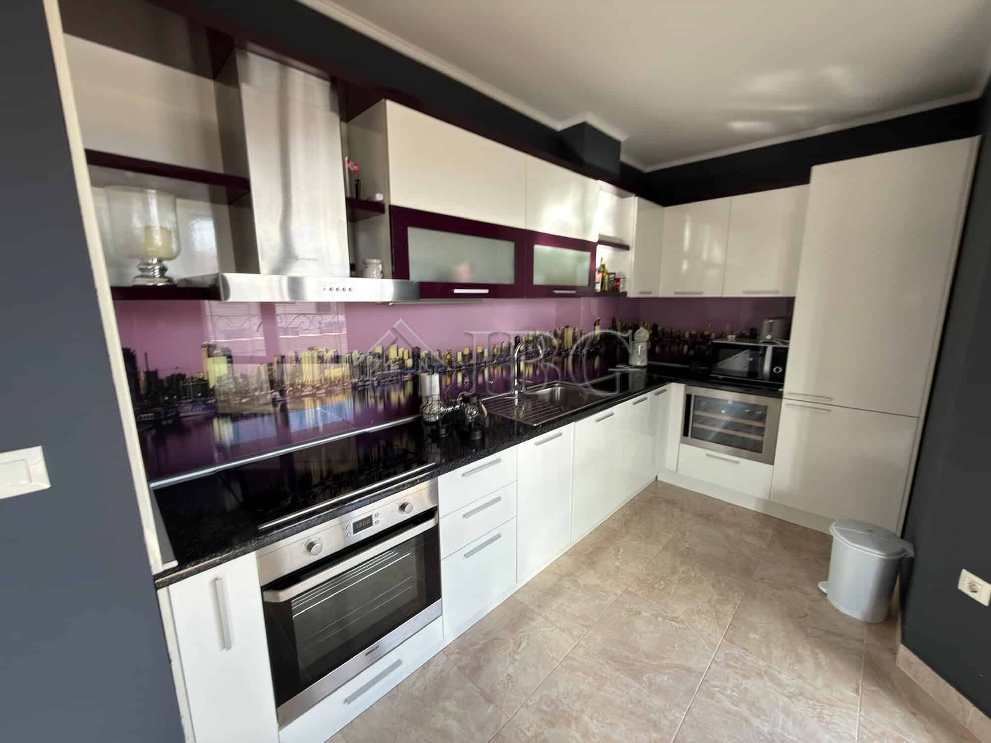Modern kitchen with sleek white cabinets and black countertops in Esteban SPA Complex, Nessebar.