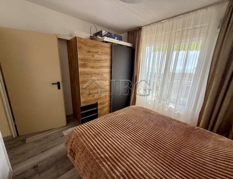 Apartment with sea view in Sveti Vlas, Bulgaria, featuring a cozy bedroom and large windows with nat.