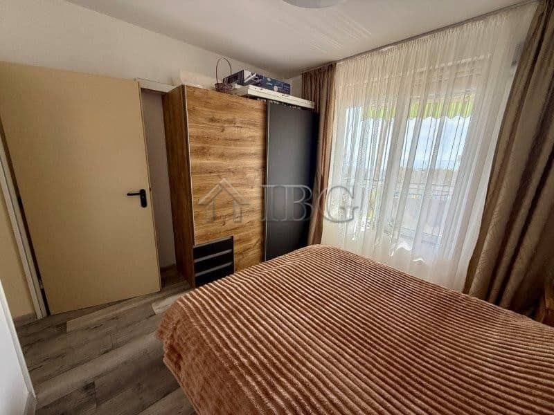Apartment with sea view in Sveti Vlas, Bulgaria, featuring a cozy bedroom and large windows with nat.