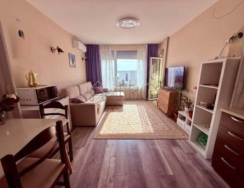 Bright living room with sea view balcony in Sveti Vlas. Modern furniture, TV, and cozy decor in a sp.