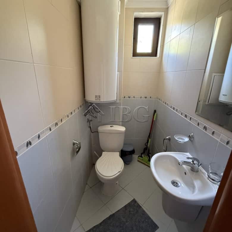 Small bathroom with toilet, sink, and water heater in Sveti Vlas.