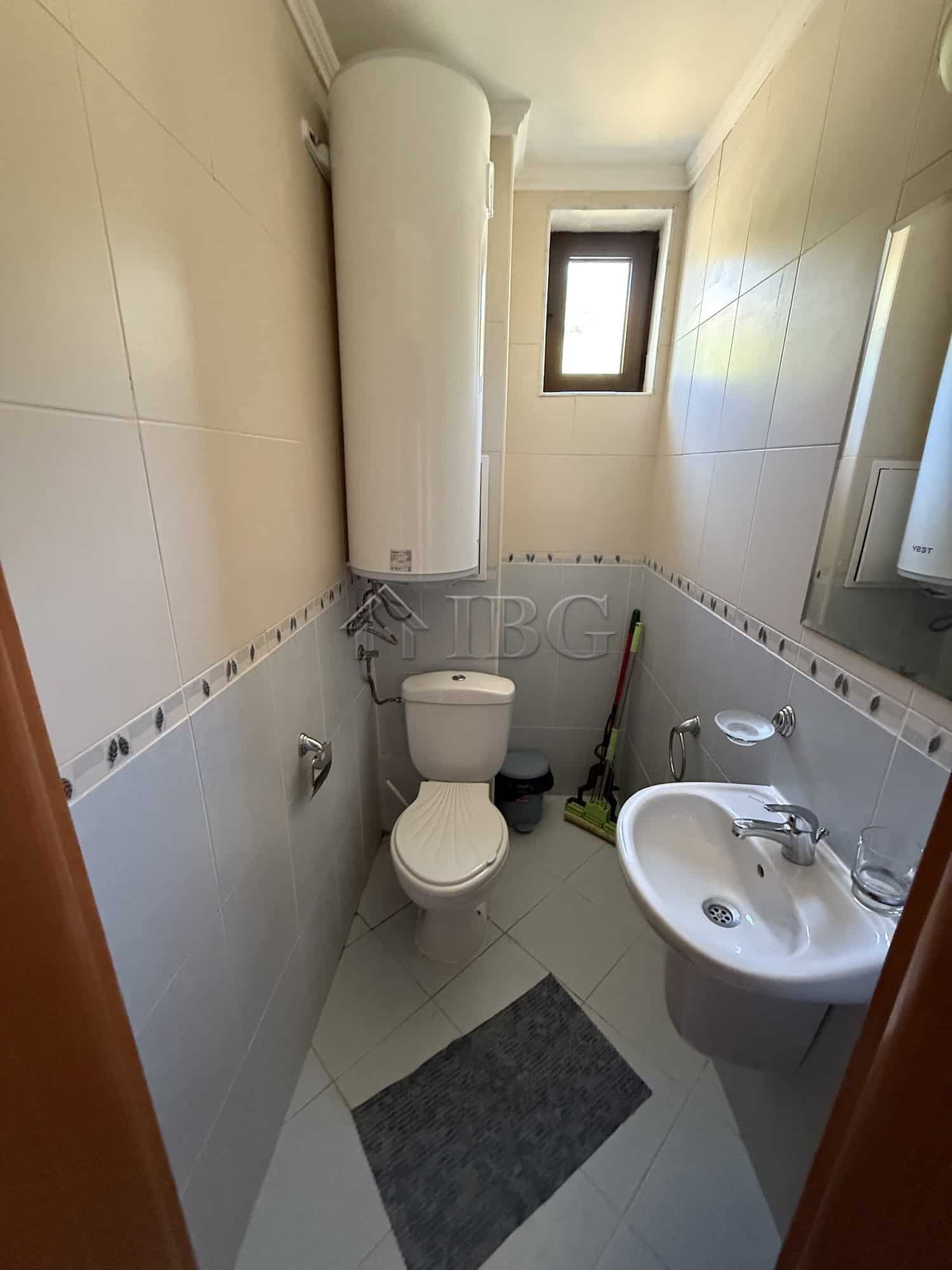 Small bathroom with toilet, sink, and water heater in Sveti Vlas.