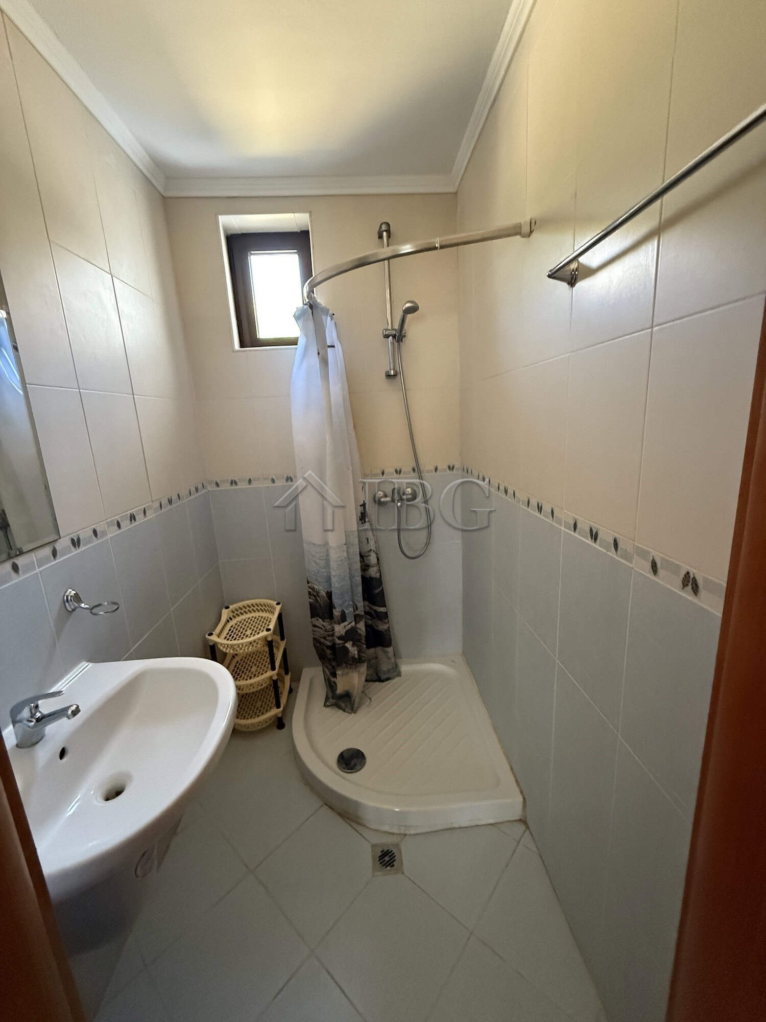Compact bathroom with shower, sink, and small window in Vodenitsata Complex, Sveti Vlas.