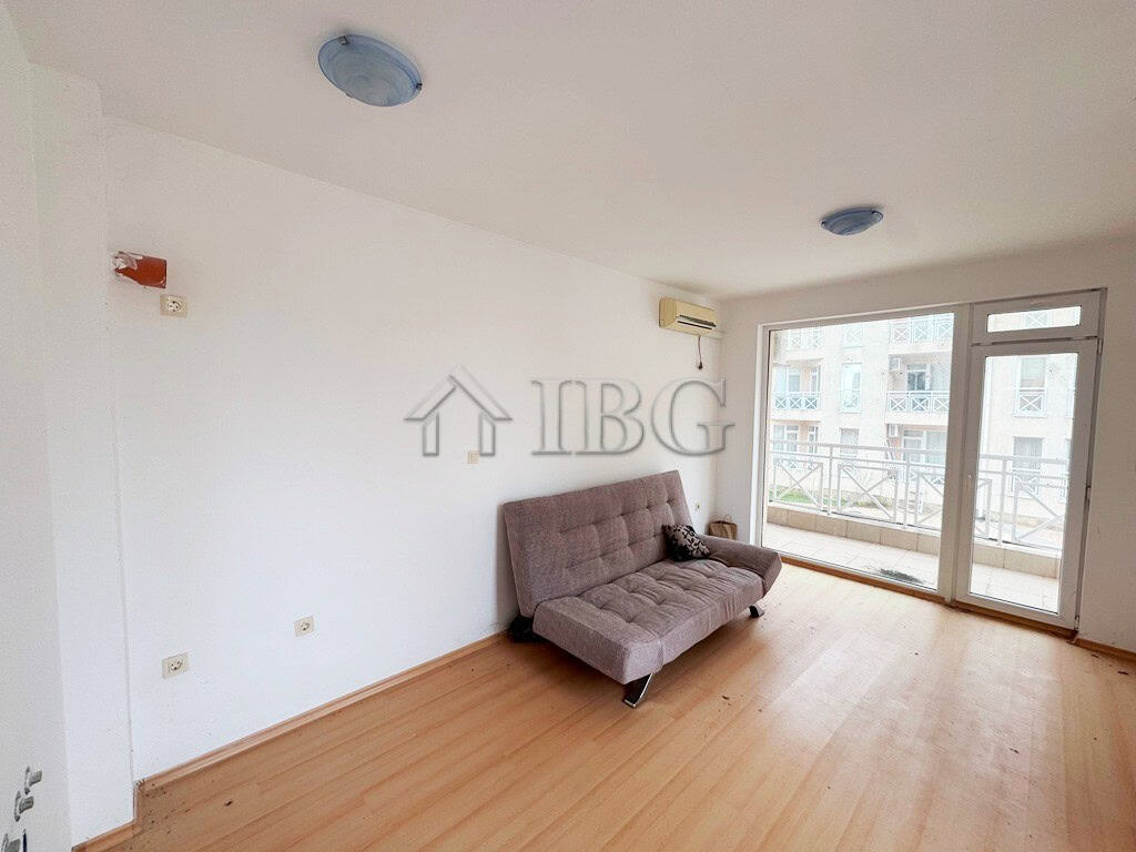 Studio apartment with balcony overlooking the pool area, perfect for sunny beach holidays.