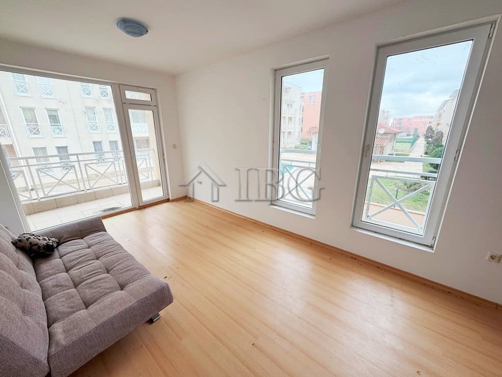 Bright studio apartment with balcony overlooking the pool, perfect for sunny beach holidays.