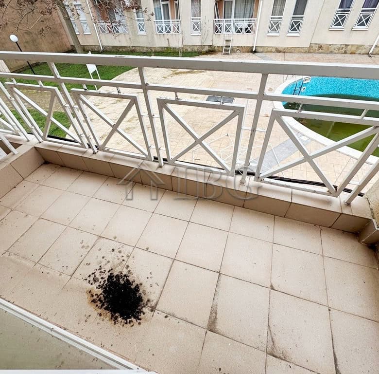 Balcony overlooking pool with a view of Sunny Beach on a sunny day.