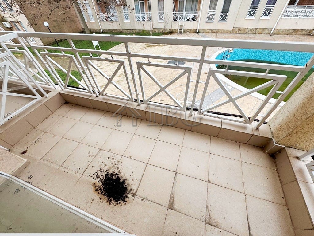 Balcony overlooking pool with a view of Sunny Beach on a sunny day.