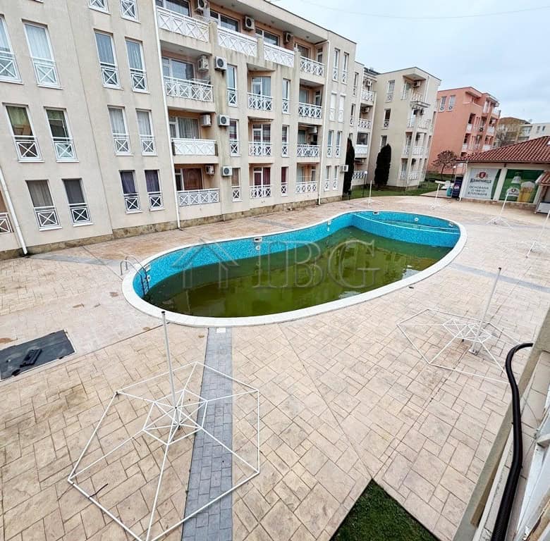 Balcony overlooking a swimming pool in a modern apartment complex at Sunny Beach.